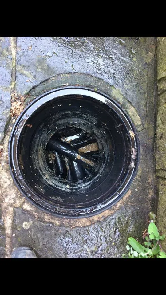 Blocked outdoor drain gully with visible debris and grime