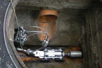 A CCTV drain inspection camera inside a manhole, ready to perform a drain survey.
