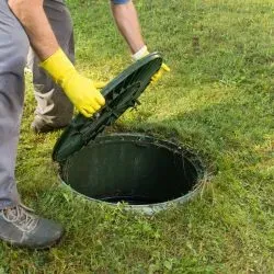 Drainage engineer opening a manhole for inspection